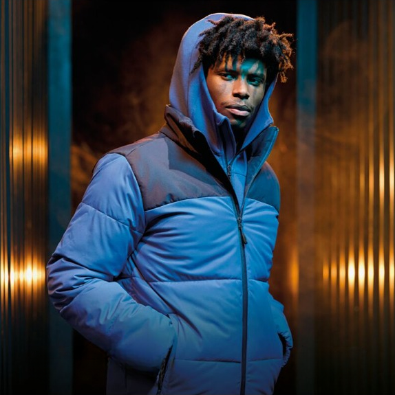 Worker in blue workwear with a hood looking directly at the camera.