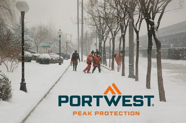 Snow-covered sidewalk with heavily bundled pedestrians, trees and people in high-visibility clothing shoveling snow. Link to our winter collection.