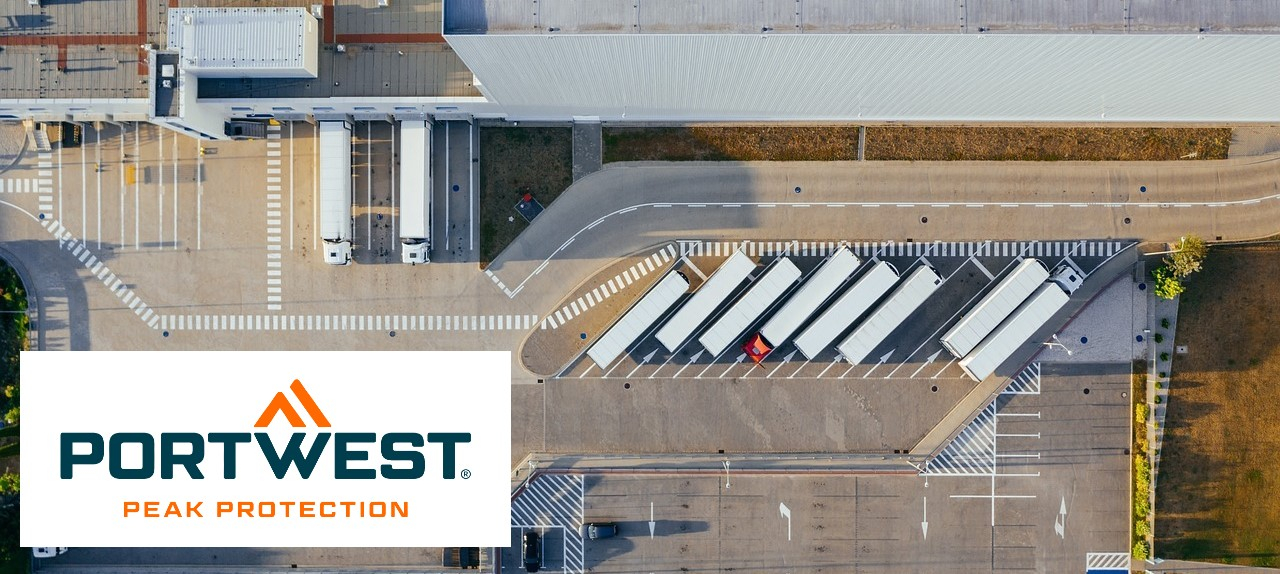 Warehouses with trucks and parked cars photographed from a bird's eye view.