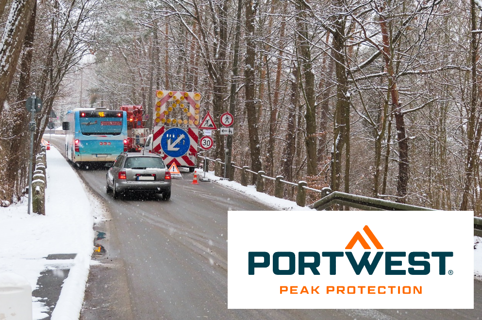 Construction site scene with bus and car on a snowy road surrounded by trees. In the right corner there is the Portwest brand logo. There is a link to the collection of thermal and cold storage clothing.