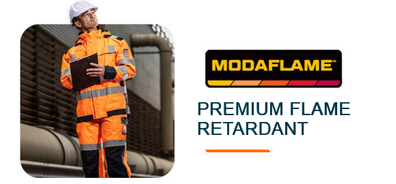 Square image of a worker in orange protective clothing with a white helmet, standing in front of an industrial building with large pipelines, holding a clipboard. To the right is the black, red, and orange Modaflame collection logo and the caption: Premium Inherent Flame Protection. A link to the items in the Modaflame collection is provided.