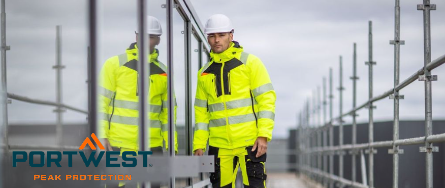 A worker in high-vis yellow work clothing with a white helmet in front of a window. You can see his reflection in the glass, and in the right half of the picture you can see the upper end of a scaffolding.