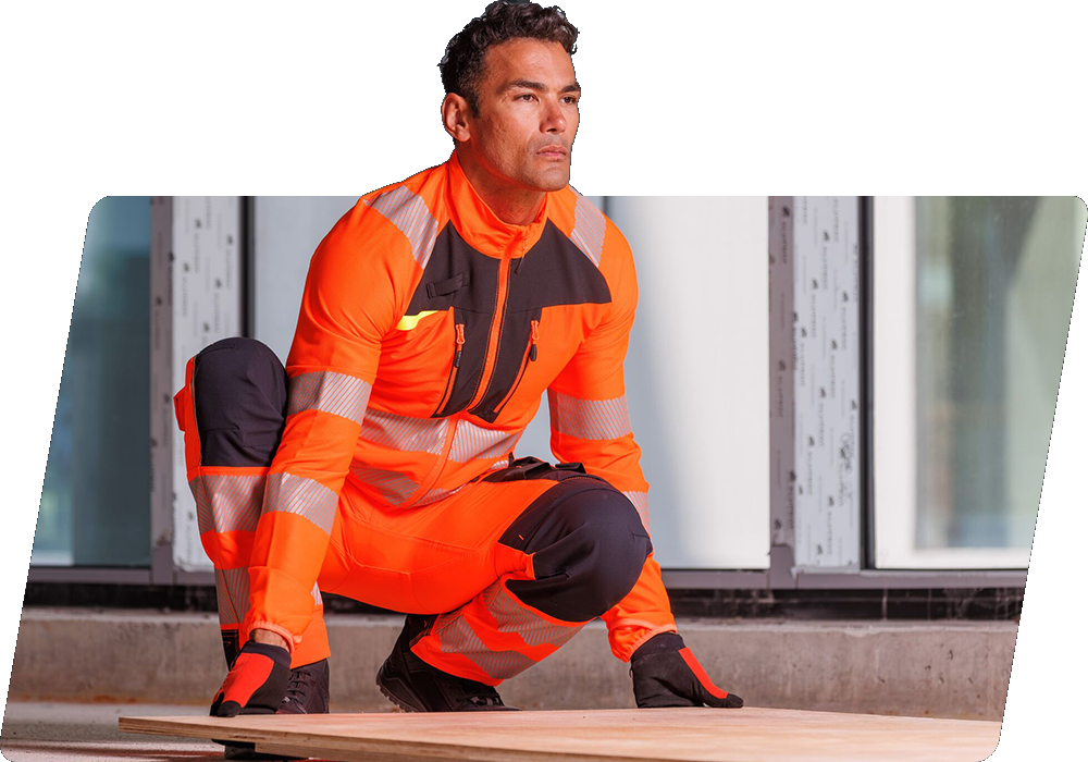 A dark-haired worker in orange high-visibility clothing lifting a wooden panel from the ground. There is a link to our DX4 collection.