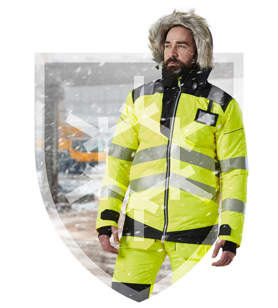 Bearded worker against a snow-drifted background in the shape of a coat of arms with a fur-lined hood on his head and high-vis yellow work clothing. Link to the winter collection.
