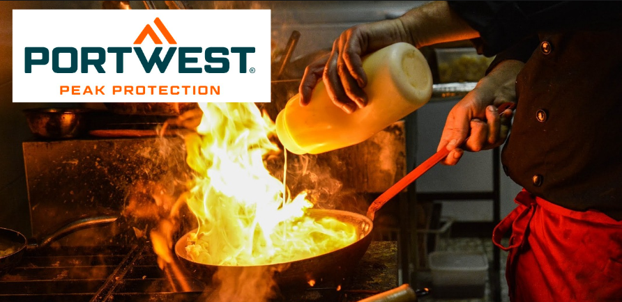 Image of a kitchen scene with a chef dressed in black and red pouring oil into a flame from which flames rise. In the upper left edge of the picture is the orange-blue Portwest logo against a white background.